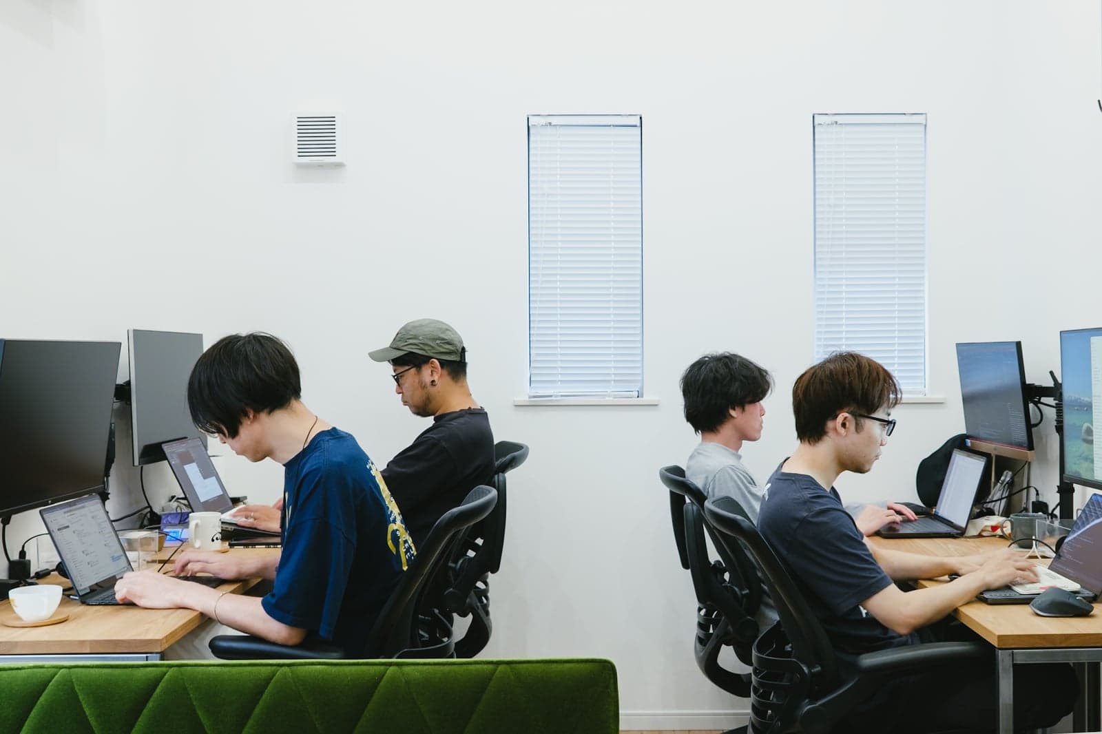 事務所のデスクスペースで作業するメンバー
