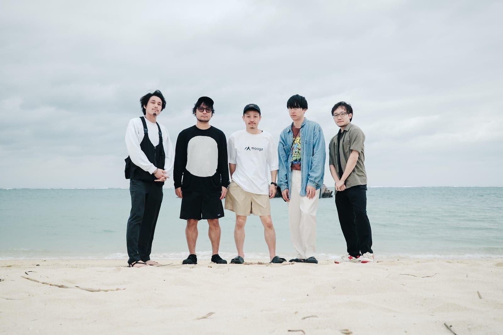 海辺に並ぶメンバー5人